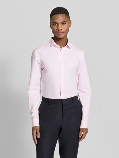 Männermodel trägt Super Slim Fit Business-Hemd Modern Kent Uni Twill von OLYMP No. Six in Hellrosa, glatte Struktur, Ganzkörperansicht von vorne.