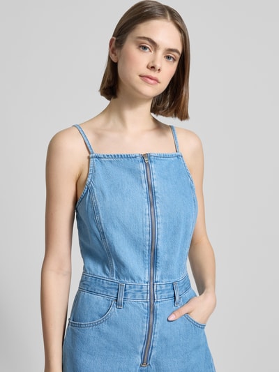 Modelka kobieca ma na sobie Regular Fit Playsuit aus Denim od Levi's®, jasnoniebieski denim, kontrastowe szwy, kwadratowy dekolt, zamek, bawełna, krój regular fit, kieszenie, pasek, regulowane ramiączka, detal z gumką w talii, zdjęcie w zbliżeniu na górę ciała.