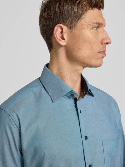 Männermodel trägt Regular Fit Businesshemd aus Baumwolle mit Kentkragen von Eterna in Hellblau, Knopfleiste, Brusttasche, Nahaufnahme Oberkörper. Rückenlänge 80 cm, Schulterbreite 49 cm, Ärmellänge 65 cm bei Größe 40.