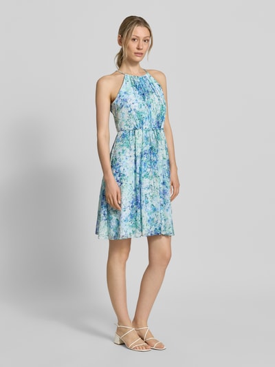 Frauenmodel trägt Minikleid in Falten-Optik mit floralem Allover-Print von Jake*s Cocktail, taillierte Passform, abnehmbares Stoffband, ärmelloses Design, in Blau- und Grüntönen, Rückenlänge bei Größe 36: 87 cm, Brustweite: 35 cm, Ganzkörperansicht von vorne.