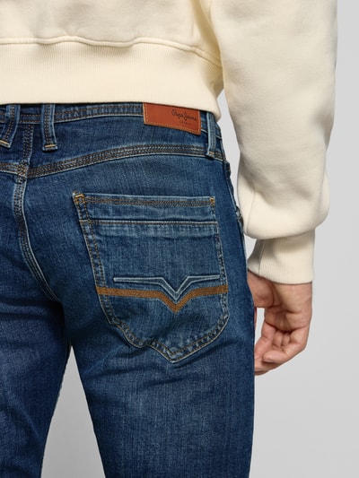 Männermodel trägt Tapered Fit Jeans aus Baumwoll-Mix Modell 'SPIKE' von Pepe Jeans in Melange-Optik mit Label-Patch, Detailaufnahme Rückansicht.