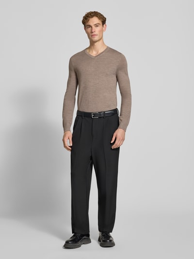 Männermodel trägt Strickpullover aus Woll-Mix mit V-Ausschnitt von Christian Berg Men in Taupe, schwarze Hose, Ganzkörperansicht von vorne. Regular Fit, gerippte Abschlüsse, Rückenlänge 71 cm, Ärmellänge 73 cm.