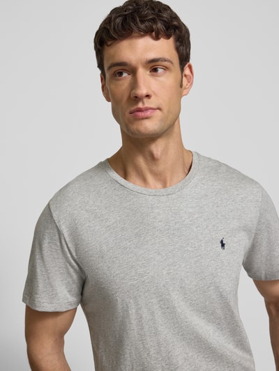 Männermodel trägt T-Shirt mit Logo-Stitching von Polo Ralph Lauren aus reiner Baumwolle, gerade Passform, Rundhalsausschnitt, Nahaufnahme Oberkörper.