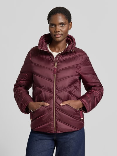 Vrouwenmodel draagt Steppjacke mit Stehkragen und Reißverschlusstaschen van Christian Berg Woman Selection, bordeaux, regular fit, zichtbare ritsdetails, gladde textuur, Ganzkörperansicht van voren, ruglengte 61 cm, schouderbreedte 42 cm, borstwijdte 51 cm, mouwlengte 58 cm.