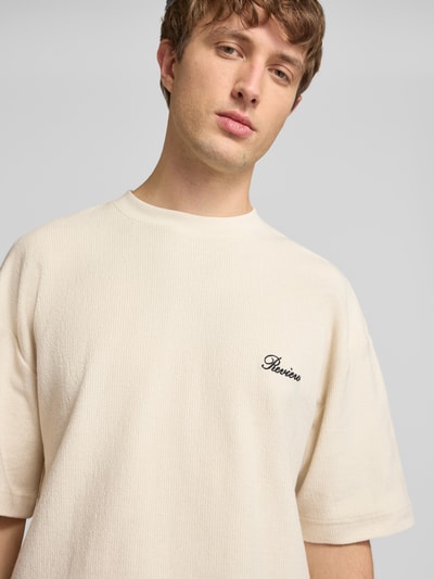 Männermodel trägt T-Shirt mit Rundhalsausschnitt und Label-Stitching von REVIEW aus Baumwoll-Mix, Relaxed-Fit, Nahaufnahme Oberkörper.