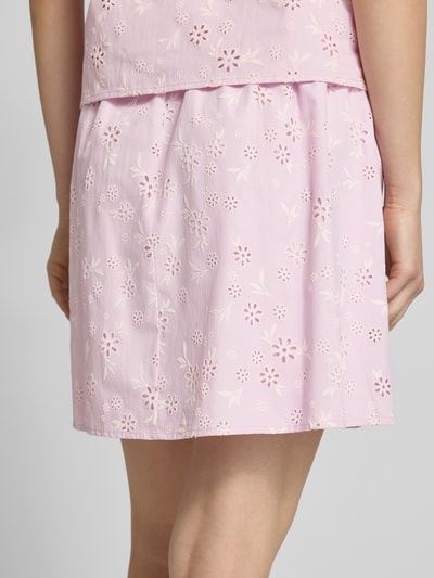 Frauenmodel trägt Regular Fit Mini-Rock aus reiner Baumwolle Modell 'BANNA' von Pieces in mehrfarbigem, floralem Popeline-Design, Ganzkörperansicht Rückansicht.