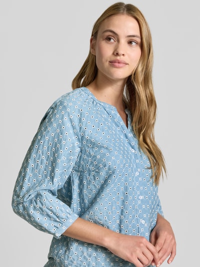 Frauenmodel trägt Regular Fit Bluse aus reiner Baumwolle Modell 'VELIA' von Brax in Hellblau mit kariertem Muster, eingestickten Luftlöchern, Label-Detail und einreihiger Knopfleiste, Nahaufnahme Oberkörper.