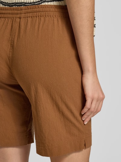 Frauenmodel trägt Shorts mit elastischem Bund Modell 'Cissie' von Soyaconcept, reine Baumwolle in Braun, Strukturstoff, Ganzkörperansicht Rückansicht.