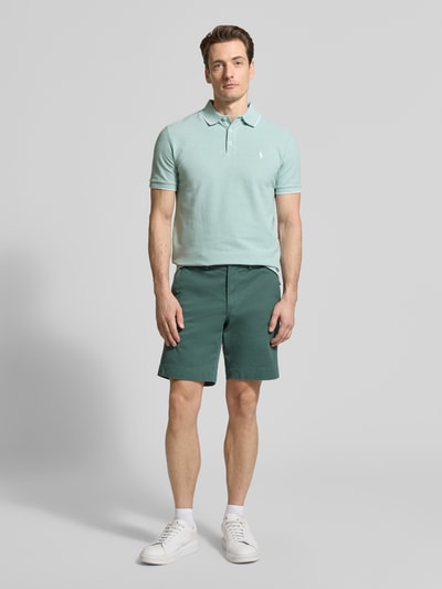 Männermodel trägt Slim Fit Poloshirt aus Baumwoll-Mix von Polo Ralph Lauren, Optik: Unifarben, Logo-Detail, Piqué, Ganzkörperansicht von vorne.