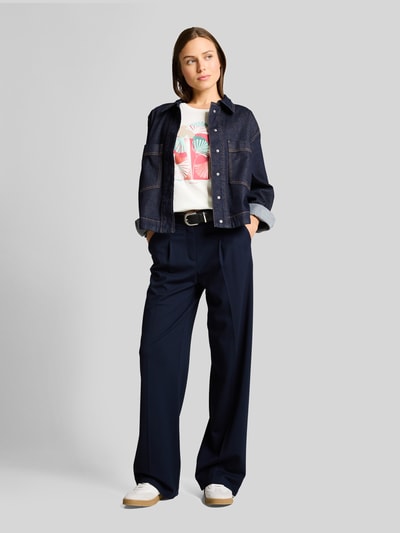 Kobiece model prezentuje Regular Fit T-Shirt aus reiner Baumwolle von Tom Tailor, koszulka biała z nadrukiem, gładka struktura, krój regular fit, okrągły dekolt, krótki rękaw, dżersej bawełniany; widok całej sylwetki z przodu.