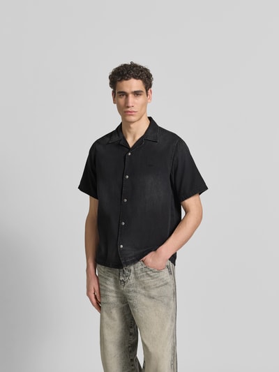 Männermodel trägt Regular Fit Jeanshemd aus Baumwolle von Diesel in Schwarz, Kurzärmelig, mit Durchgehender Druckknopfleiste und Reverskragen, Ganzkörperansicht von vorne.