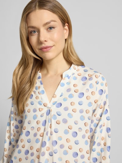 Frauenmodel trägt Regular Fit Bluse aus reiner Viskose Modell 'Josy' von ZABAIONE mit blau-braunem Tupfenmuster, Tunika-Kragen, elastischen Ärmelabschlüssen, Nahaufnahme Oberkörper.