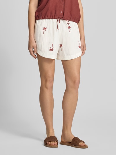 Frauenmodel trägt Relaxed Fit Shorts aus reiner Baumwolle Modell 'KIANA' von Pieces, unifarben weiß mit Stickerei, Ganzkörperansicht von vorne