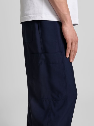Männermodel trägt Straight Fit Sweatpants aus Viskose-Mix von Kenzo in Dunkelblau mit Cargo-Tasche, elastischem Bund und Tunnelzug, Nahaufnahme Oberkörper.