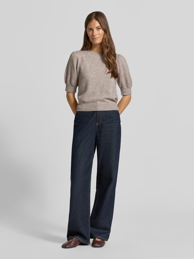 Frauenmodel trägt Regular Fit Pullover mit Puffärmeln von VERO MODA, meliert in Beige, kombiniert mit dunkler Jeans, Ganzkörperansicht von vorne.