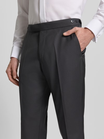 Männermodel trägt Stoffhose mit Bundfalten von Wilvorst, dunkler Baumwoll-Mix, gerader Schnitt, Nahaufnahme Oberkörper, französische Eingrifftaschen.