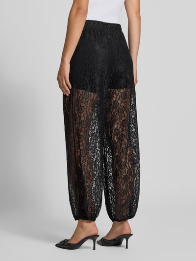 Frauenmodel trägt schwarze Weite Hose in Spitzen-Optik Modell 'BEA' von ONLY, transparente Textur, Ganzkörperansicht Rückansicht, Damen Weite Hose von ONLY.