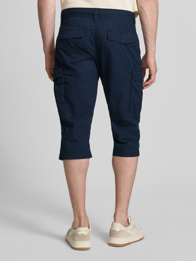 Męski model nosi Relaxed Fit Cargoshorts aus Baumwoll-Mix od s.Oliver BLACK LABEL, granatowy, popelina, krój relaxed fit, widok całej sylwetki z tyłu.