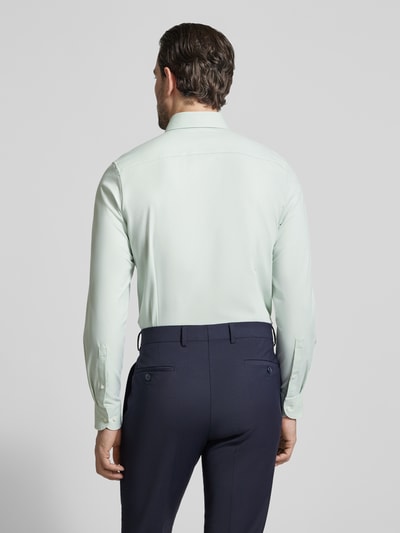 Männermodel trägt Slim Fit Business-Hemd mit Kentkragen von OLYMP, hellgrün, glatter elastischer Baumwoll-Mix, Rückansicht, Ganzkörperansicht.