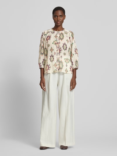 Frauenmodel trägt Regular Fit Bluse mit 3/4-Arm Modell 'ODELIE' von Bash aus reiner Baumwolle im Allover-Look mit Stitchings, Rundhalsausschnitt, in Creme mit buntem Muster, Ganzkörperansicht von vorne.