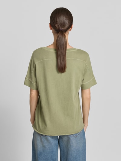Modelka kobieca ma na sobie Relaxed Fit T-Shirt aus reiner Baumwolle od s.Oliver RED LABEL, kolor jednolity, krótki rękaw, okrągły dekolt, materiał czysta bawełna, logo, widok całej sylwetki od tyłu.