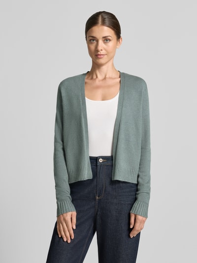 Frauenmodel trägt Strickjacke aus Viskose-Mix von VILA in Hellgrün mit geripptem Bund und gerippten Ärmelabschlüssen, gerade Passform, Ganzkörperansicht von vorne.