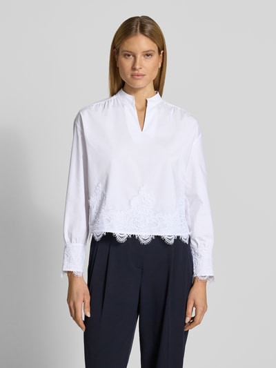 Frauenmodel trägt Regular Fit Bluse mit Spitzenbesatz von More & More, weiß, elastischer Baumwoll-Mix, Tunika-Kragen, Ganzkörperansicht von vorne.