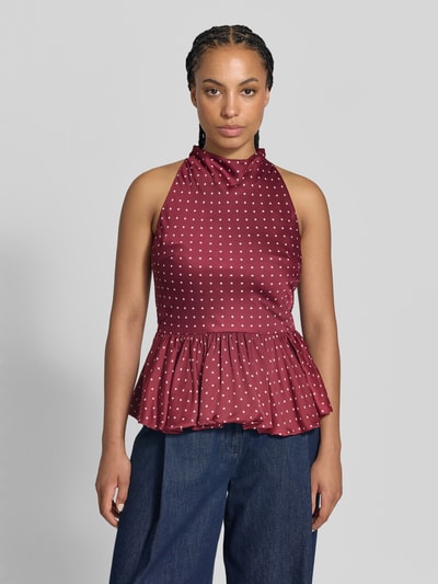 Frauenmodel trägt Slim Fit Bluse mit Peplum-Saum von ROTATE, bordeaux Satin, floraler Allover-Print, ärmellos, Ganzkörperansicht von vorne.
