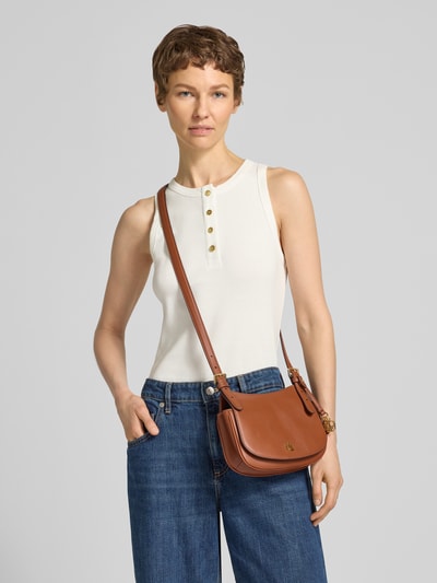 Kobiece modelka nosi Umhängetasche mit Logo-Detail von Lauren Ralph Lauren, jednokolorowy brąz, skóra gładka, detal z logo, zapięcie na magnes, główna przegroda, przegródka wewnętrzna, pasek na ramię, kształt owalny, naturalna skóra bydlęca, Ganzkörperansicht von vorne.