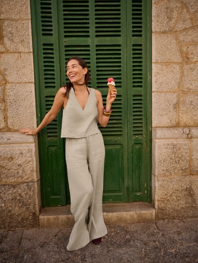 Frauenmodel trägt Leinenhose mit elastischem Bund curated by Anna Schürrle von Style Icon Collection in Beige, Wide Leg Fit, reines Leinen, Ganzkörperansicht von vorne.