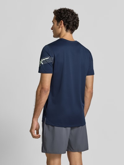 Męski model nosi Regular Fit T-Shirt mit Label-Print Modell 'ICON' von ASICS TIGER, granatowy, okrągły dekolt, Długość tyłu w rozmiarze M: 71 cm, Ganzkörperansicht Rückansicht