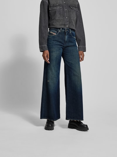 Frauenmodel trägt Wide Fit Jeans mit 5-Pocket-Design von Diesel in Blau, Baumwoll-Lyocell-Mix, Lockerer-Schnitt, Label-Detail, Ganzkörperansicht von vorne.