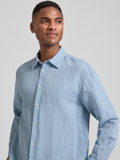 Männermodel trägt Regular Fit Freizeithemd aus Leinen-Baumwoll-Mix Modell 'CLAY LINENBLEND' von SELECTED HOMME mit Kentkragen, Melange-Optik, durchgehender Knopfleiste, langarm, 2-Knopf-Manschette, Flammgarn-Material, fein gestreiftes Muster, Blautöne, Nahaufnahme Oberkörper.