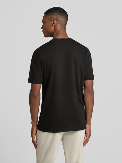 Männermodel draagt T-Shirt met Label-Schriftzug Modell 'DULIVIO' van HUGO, zwart, rechte pasvorm, pure katoen, unidesign, Ganzkörperansicht Rückansicht.