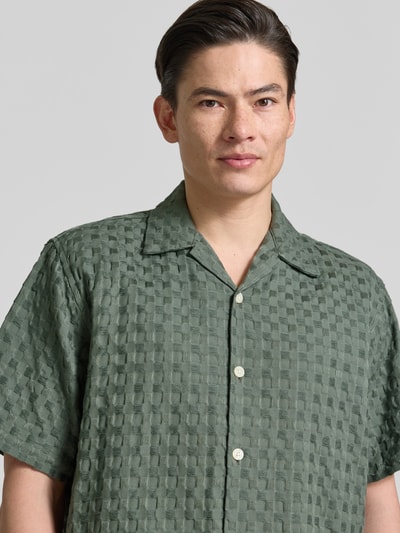 Männermodel trägt Relaxed Fit Freizeithemd aus reiner Baumwolle Modell 'MONTY' von SELECTED HOMME, grün, Jacquard, Resortkragen, Nahaufnahme Oberkörper.