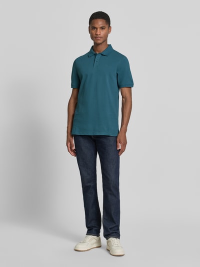 Męski model nosi Regular Fit Poloshirt aus reiner Baumwolle von s.Oliver RED LABEL, efekt: jednolity kolor, pika, wyhaftowane logo, kołnierzyk polo, dekolt w serek, listwa guzikowa, krótki rękaw, prążkowane zakończenie rękawów, wykończenie z bocznymi rozcięciami, bawełna, całkowity widok od przodu.