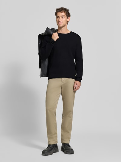 Männermodel trägt gebreide pullover met structuurpatroon Model 'BLUMASON' van JACK & JONES premium, puur katoen, recht model, ronde hals, labelpatch, ruglengte maat M 68 cm, mouwlengte maat M 66 cm, zwart, beige broek, grijze achtergrond, Ganzkörperansicht van voren