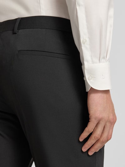 Männermodel trägt Regular Fit Anzughose mit Woll-Anteil Modell 'MADDEN 2.0' von Strellson, efekt: jednolity kolor, wpuszczane i tylne kieszenie, kanty, szlufki, krój regular fit, zapięcie na haftkę i zamek błyskawiczny, dodatek wełny, widoczna struktura materiału, rozmiar 52: szerokość w pasie 46 cm, długość wewnętrzna nogawki 79 cm, detal z tyłu, detailaufnahme.