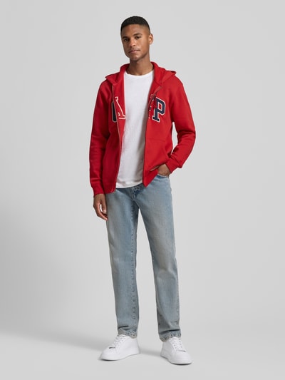 Männermodel trägt Sweatjacke mit Logo und Känguru-Tasche von GAP aus Baumwoll-Mix, Regular-Fit, Reißverschluss, Ganzkörperansicht von vorne.