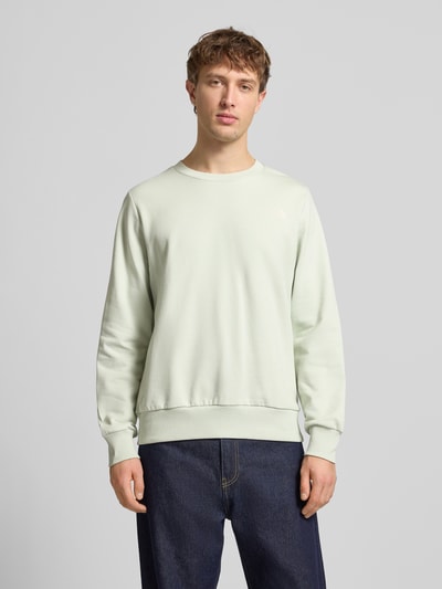 Männermodel trägt Sweatshirt mit Label-Print von The North Face, Reine Baumwolle, Lockerer-Schnitt, Gerippte-Abschlüsse, Rundhalsausschnitt, Ganzkörperansicht von vorne