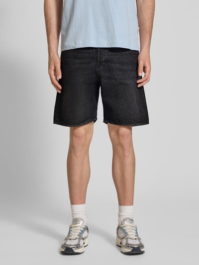 Männermodel trägt Loose Fit Jeansshorts mit Eingrifftaschen Modell 'TONY' von Jack & Jones in Schwarz, Used-Look, Reine Baumwolle, Nahaufnahme Oberschenkel, Kontext: Herren Jeansshorts, Bundweite Größe M 42 cm, Innenbeinlänge 21 cm.