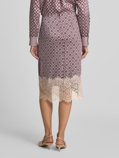Frauenmodel trägt Midirock mit Spitzenbesatz Modell 'LONGUETTE' von Liu Jo White, asymmetrisches Design, Zierbesatz, Ganzkörperansicht Rückansicht.