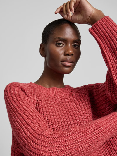 Frauenmodel trägt Pullover aus Woll-Mix in Strick-Optik von Joseph in Rot, lockere Passform, gerippter Rundhalsausschnitt, gerippte Abschlüsse, Woll-Kaschmir-Mix mit Seide-Anteil, Rückenlänge bei Größe S 120 cm, Nahaufnahme Oberkörper.