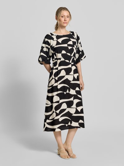 Frauenmodel trägt Soyaconcept Midikleid aus Reine Viskose Modell 'CHANISE' mit A-Linie, Allover-Look, Rundhalsausschnitt, Ganzkörperansicht von vorne. Rückenlänge bei Größe S: 119 cm, Brustweite 48 cm, Ärmellänge 28 cm.