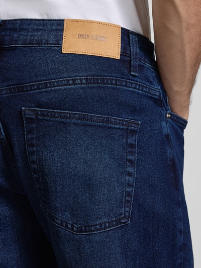 Männermodel trägt Regular Fit Jeans aus Baumwoll-Mix Modell 'WEFT' von Only & Sons, unifarben, Label Patch, Detailaufnahme Rückansicht