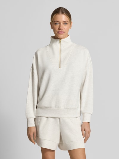 Frauenmodel trägt Sweatshirt aus Viskose-Mix mit Reißverschluss Modell 'hawley' von VARLEY, cremefarben, Stehkragen, Regular Fit, Ganzkörperansicht von vorne.