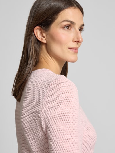 Frauenmodel trägt Strickpullover mit gerippten Abschlüssen Modell 'dalo' von Vila in Rosa, reine Baumwolle, Nahaufnahme Oberkörper.