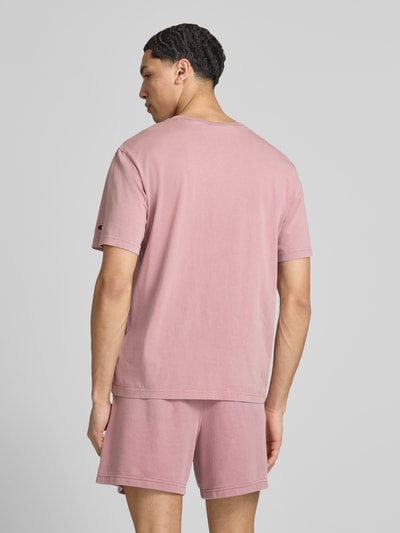 Männermodel trägt T-Shirt mit Label-Stitching und Rundhalsausschnitt von CHAMPION in Rosa, Reine Baumwolle, Regular-Fit, Rückenlänge 67 cm, Ganzkörperansicht Rückansicht.