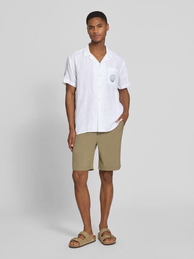Männermodel trägt Regular Fit Leinenhemd mit Stitchings Modell 'Ilfracombe' von BOARDIES in Weiß, Reverskragen, Brusttasche, Ganzkörperansicht von vorne, Herren Freizeithemd aus reinem Leinen, Größe M: Rückenlänge 75 cm, Schulterbreite 48 cm, Ärmellänge 23 cm.