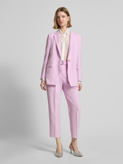 Frauenmodel trägt Regular Fit Schmale Hose mit Gürtel Modell 'TAPIAH' von BOSS in zartem Rosa, High Waist, unifarben, Bügelfalten, Ganzkörperansicht von vorne.